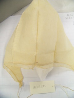 Photo shows center seam of caul, with fine stitches and red initial.